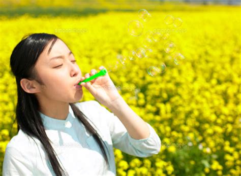 菜の花とシャボン玉をする日本人の女の子[11004009795]の写真素材・イラスト素材｜アマナイメージズ