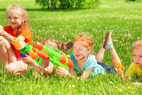Children Play With Water Guns On A Meadow Stock Image Image Of Kids