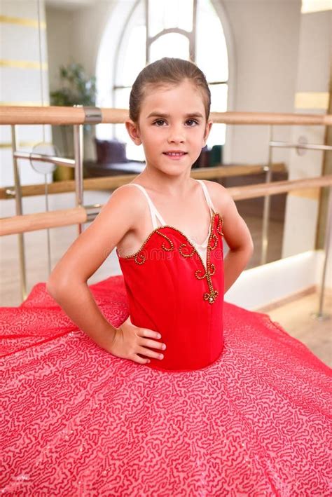 full length portrait of a cute little ballerina in a performance dress in a dance hall with