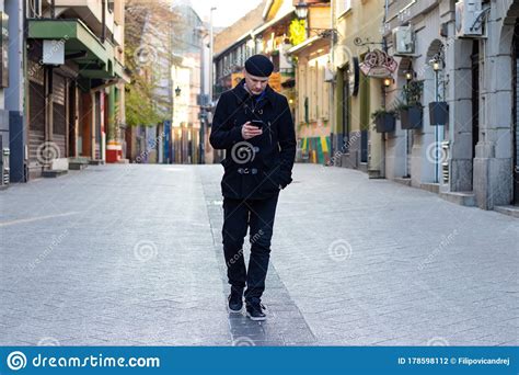 Stylish Young Man Walking Alone On Empty City Streets Stock Photo