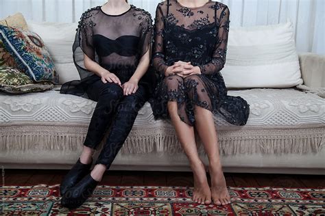 Two Beautiful Women Sitting On The Couch In Black Dresses Del