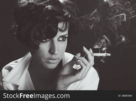 Elegant Brunette Woman Smoking A Cigarette On Black Background Free