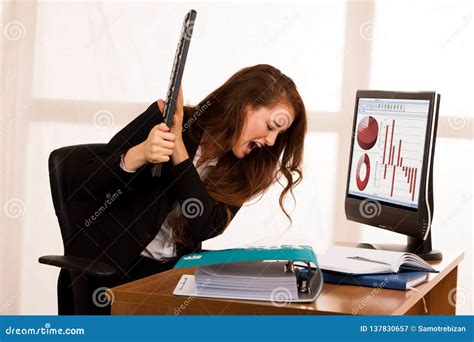 Angry Business Woman Expressing Rage At Her Desk In The Office Stock