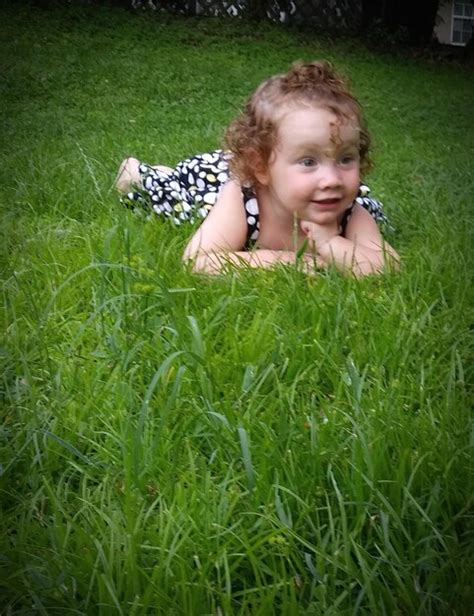 premium photo cute girl looking way while lying on grassy field