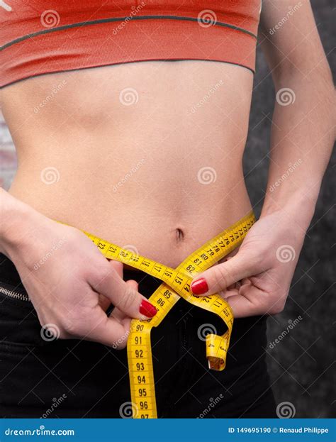Girl Is Measuring Her Waist With Measuring Tape Close Up Stock Photo