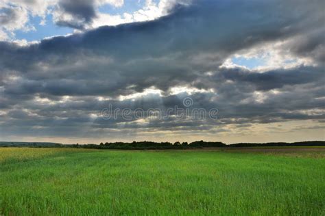 Sunny Rays In Dark Clouds Over A Green Meadow Stock Photo Image Of