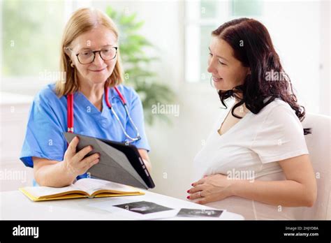 Doctor examining pregnant woman. Pregnancy check. Young Asian female at