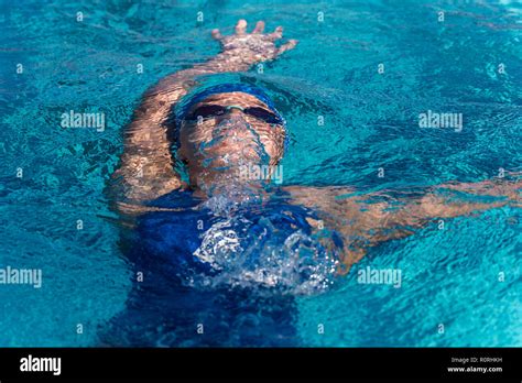 Female Swimmer Still Submerged As She Ascends To The Surface Of Pool