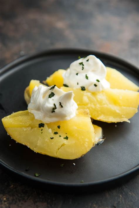 Using tongs, remove aluminum foil and place potatoes over direct heat for 1 minute per side. How to Make a Baked Potato on the Grill - Garnished Plate