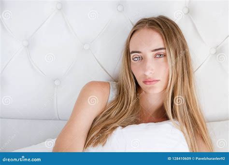 Portrait Of Yound Sad Woman Lying On Bed In Light Room Loss Of