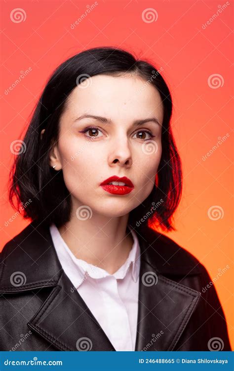 Brunette Woman With Red Lipstick On Her Lips In A Black Leather Jacket And White Shirt Red