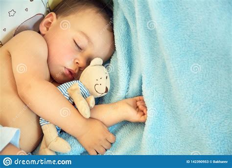 Sleeping Baby With A Soft Toy Bear Little Boy Lying In Crib On A Blue