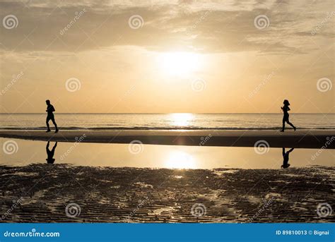 Man And Woman Running Together On The Beach In Sunset Sunrise
