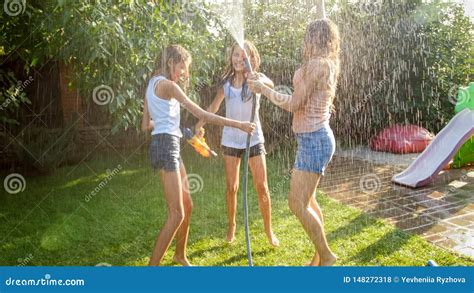 Image Of Cheerful Laughing Girls In Wet Clothes Dancing In The Garden