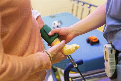 Doctor Measuring Blood Pressure On Leg Of Baby Boy Stock