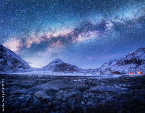 Milky Way Above Snow Covered Mountains And Stones Beach In Winter At