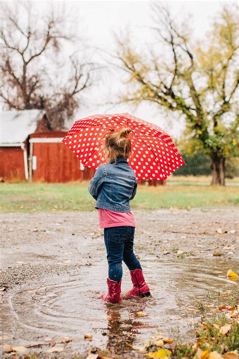 Toddler Girl Playing Outside On A Rainy Day With A Red Polka Dot ...