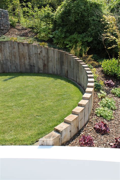 Vertical Sleepers Creating A Lovely Staggered Wall With Planting
