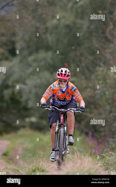 Young Woman Riding A Mountain Bike Uphill Stock Photo Alamy