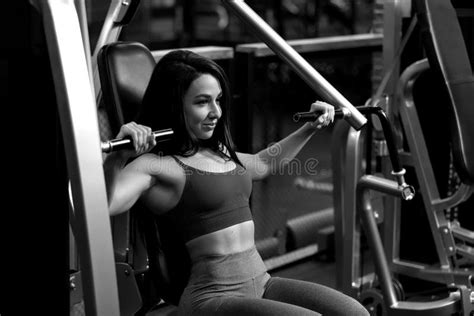 fitness brunette girl is sitting and doing shoulder exercises in trainer stock image image of