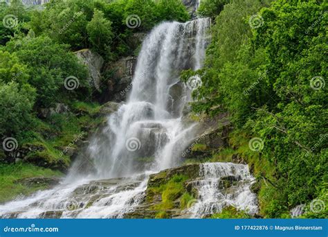 Beautiful Waterfall Surrounded By Lush Green Vegetation Stock Photo