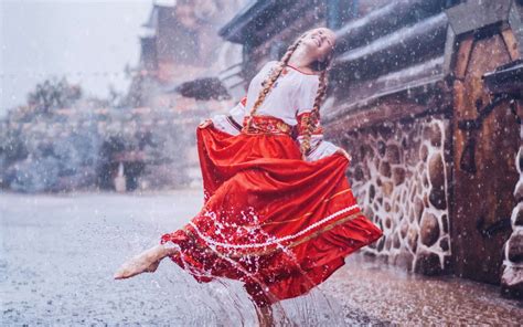 Обои на рабочий стол Девушка в блузе и красной юбке танцует под дождем фотограф Кристина
