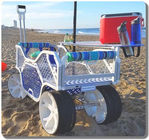 A White Cart With Blue And Green Handles On The Beach