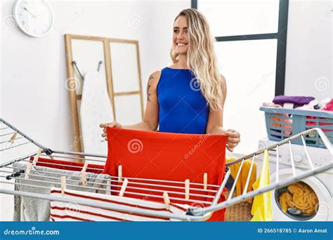 Young Woman Smiling Confident Hanging Clothes On Clothesline At Laundry