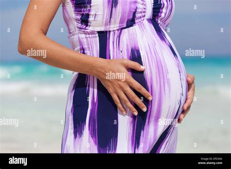 Pregnant Woman On Tropical Beach On Turquoise Caribbean Sea Holding