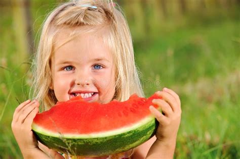 Niña Pequeña Comiendo Trozos De Sandía En El Jardín Sentado En Una