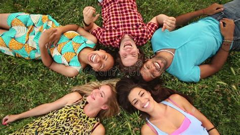 Group Of Happy Friends Forming A Circle With Their Heads Laying Back On Grass Stock Footage