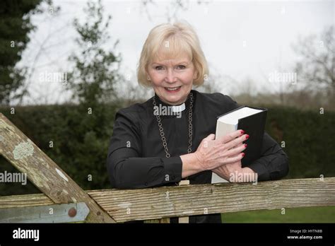 Elderly Woman Vicar Leaning On A Garden Gate Stock Photo Alamy