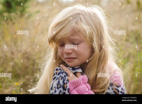 Little Lovely Girl With Long Blond Hair Crying Alone In Autumn Nature