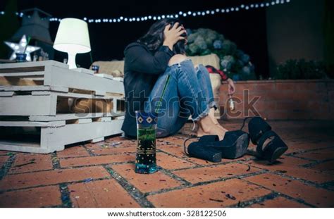 Closeup Of Young Drunk Woman Holding Her Head Sitting In The Floor After Outdoors Party Fun And