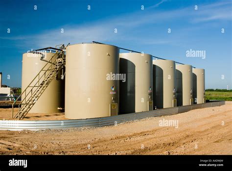Crude Oil Storage Tanks With A Drilling Rig In The Background Texas