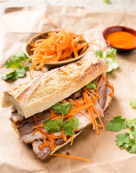 Vietnamese bbq with fire charred pork skewers and patties, crispy roll, served with a noodle and vegetable platter. vietnamese banh mi with gochujang mayo - glebe kitchen