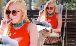 lindsay lohan catches up on scripts while puffing on an electronic cigarette during house arrest