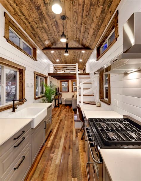 The Interior Of A Tiny House With Wood Flooring And White Counter Tops