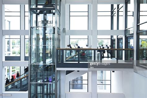 Modern Business Hall With Blurred People Stairs Escalators And Elevator
