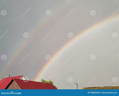 Rainbow In The Sky Above The Roof Of The House Stock Photo Image Of