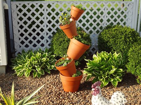 Several Clay Pots With Plants In Them On The Side Of A Fenced Garden Area