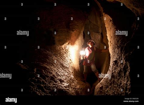 A Filipino Tour Guide Holds A Lantern Inside Sumaging Cave Or Big Cave