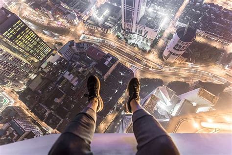 Man Sitting Roof City Building Feet Shoes Hanging Edge Over The