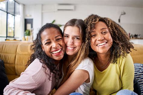 Three Mixed Race Happy Female Friends Hugging Smiling Funny Women Together Celebrating Sitting