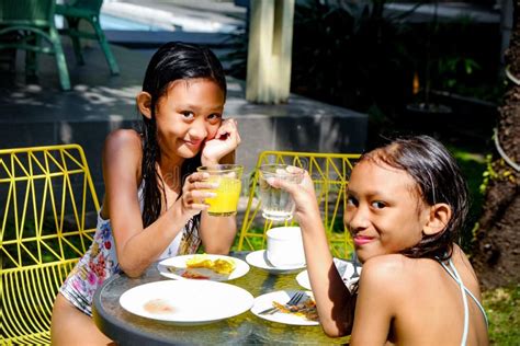 Two Asian Girls In Swimsuit Having Some Meals After Swimming Activities