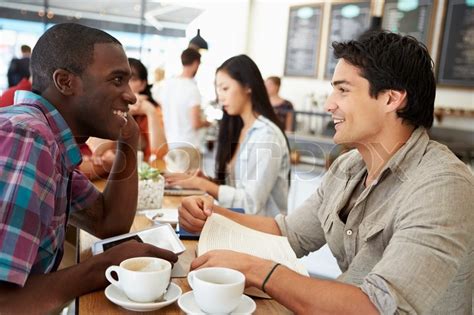 Two Male Friends Meeting In Busy Coffee Stock Image Colourbox