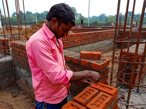 An Indian Village Labour Fixing Bricks On Wall During Construction Work