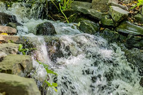 Stream With A Small Waterfall With The Water Flowing Between The Rocks