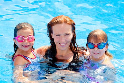 töchter und mutter familie schwimmen im pool Lizenzfreies Foto