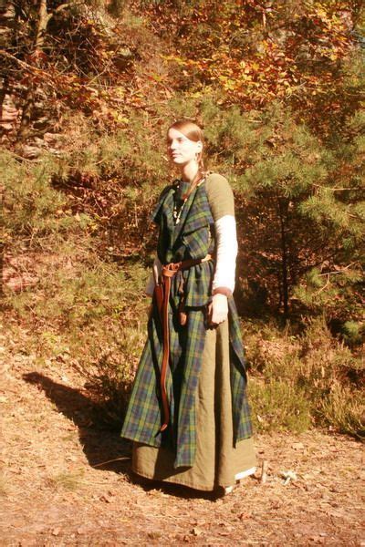 A Woman Wearing A Long Dress Standing In The Woods